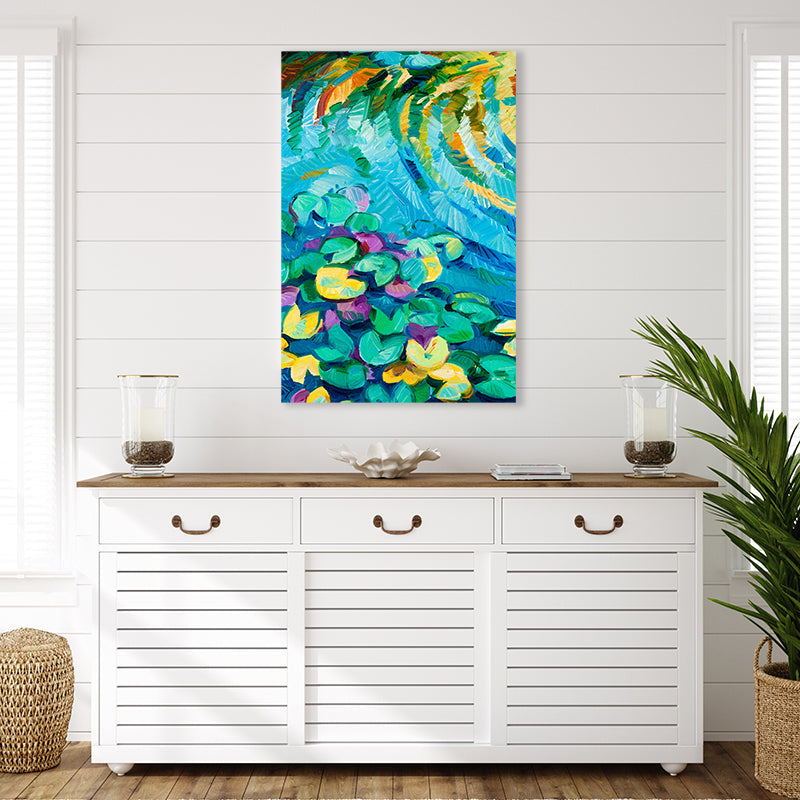 Colourful art print of an aqua blue lily pond with green and yellow water lily pads, set in a white tropical-style interior.