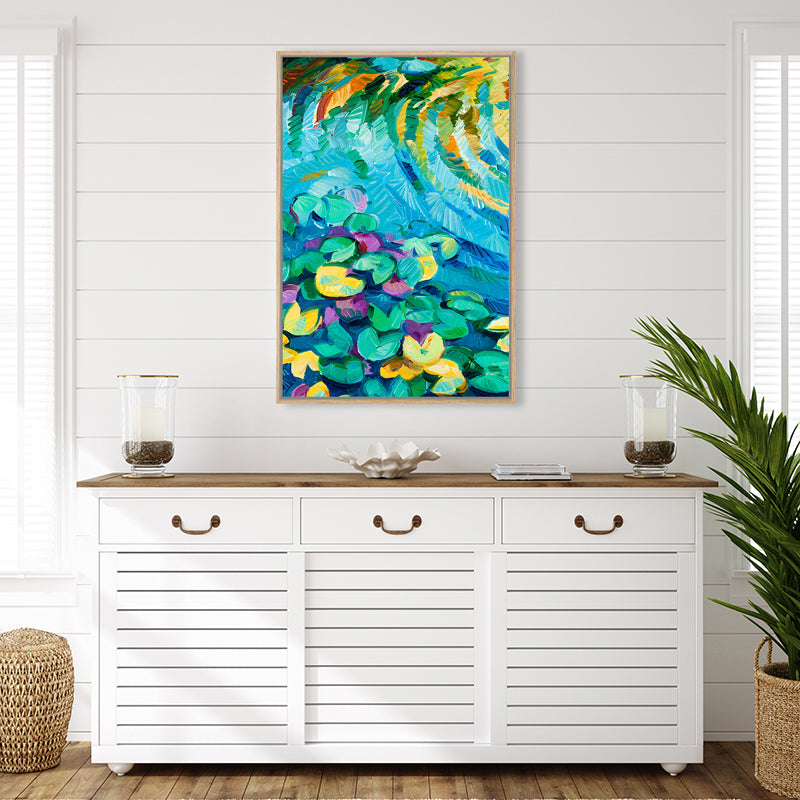 Canvas art print of an aqua blue lily pond with green and yellow water lily pads, set in a white tropical-style interior.