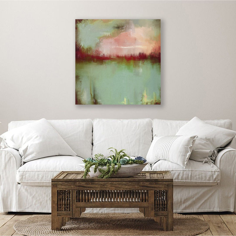 Abstract canvas wall art print of a sage green lake and crimson sunset, displayed above a white linen couch in a country-style living room.