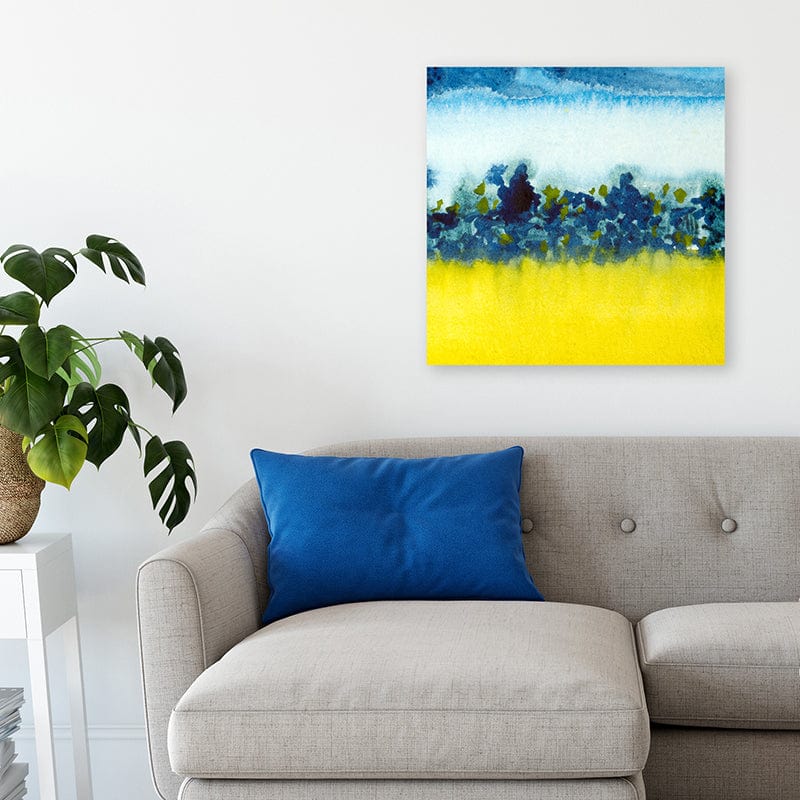 Blue and yellow abstract watercolour landscape art print above grey sofa and bright blue cushion in modern interior.